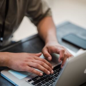Person typing on laptop keyboard